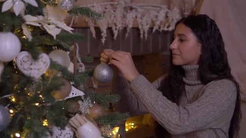 Young Woman Decorates Beautiful Christmas Tree at Home