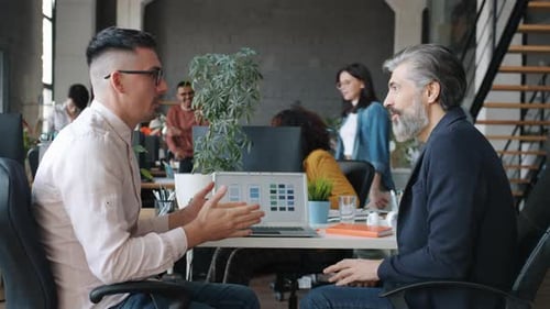 Businessmen Discuss Strategy and High Five at Office
