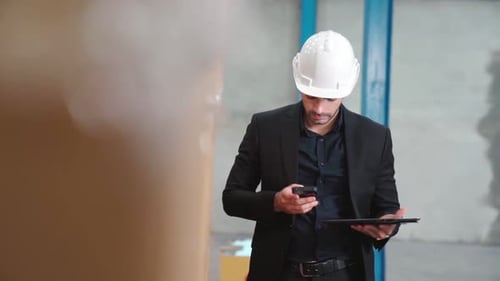 Factory Manager Using Tablet Computer in Warehouse or Factory