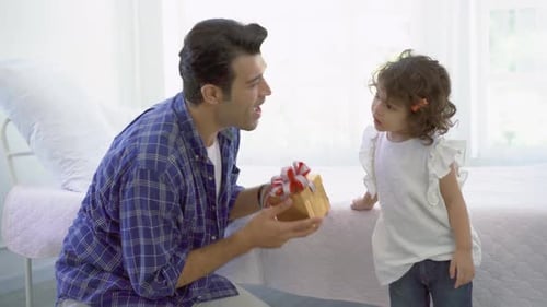 Father Presents Gift to Daughter at Home