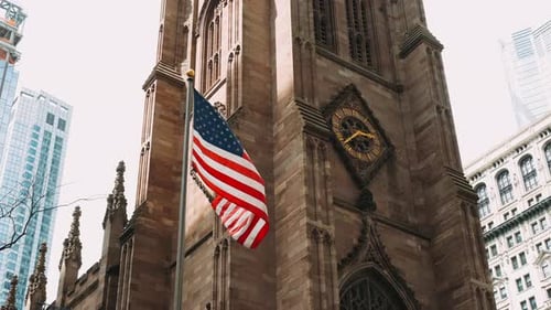 American Flag Waving Before Gothic Style Church