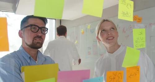Front View of Diverse Business Executives Discussing Over Sticky Note in Office