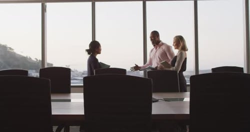 Professional businesspeople shaking hands in modern office in slow motion