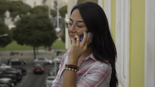 Smiling Woman Chatting on Mobile Phone in City