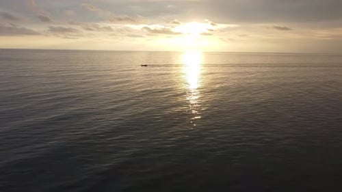 Aerial move toward fishing boat move at sea during sunset
