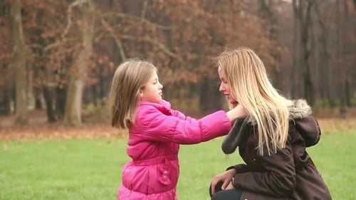 Loving Mother and Daughter Playing Together in Autumn Park