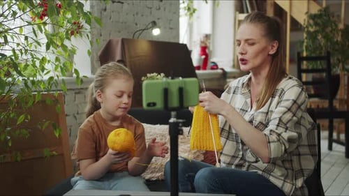 A Woman and Her Child Talk About Knitting Techniques Together During the Stream