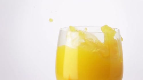 Orange Slice Splashing into Glass of Juice