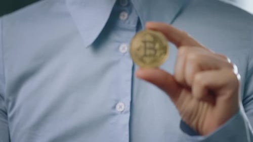 Close Up of Hand Holding Golden Bitcoin