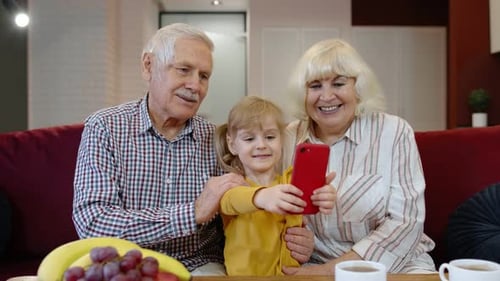 Child Taking Photo with Seniors on Couch