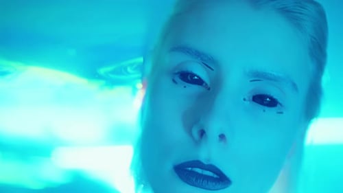 Porträt einer Frau mit Alien-Make-up im Laserlicht