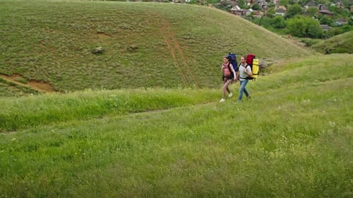 Couple Hiking With Backpacks in Rural Landscape