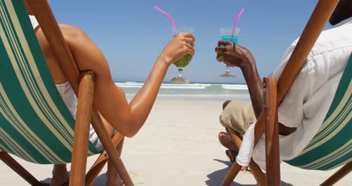 Couple toasting glasses of cocktails at beach 4k