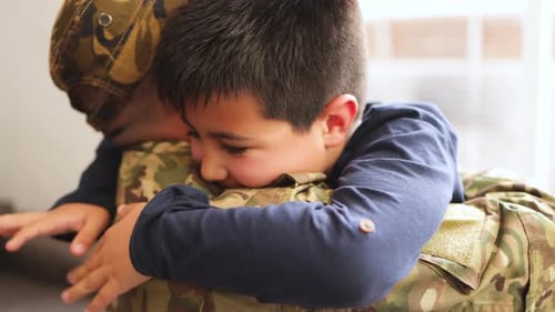 Child Embracing Adult in Military Uniform