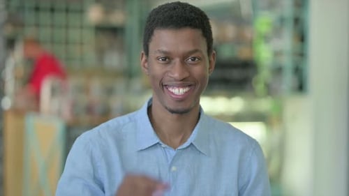 Young Adult Smiling and Giving Okay Hand Gesture