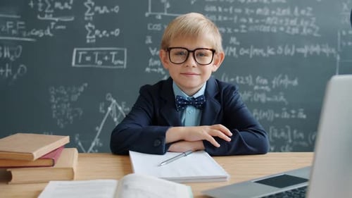 Smiling Boy at School Desk with Chalkboard
