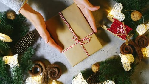 Gift Being Placed Among Christmas Decorations