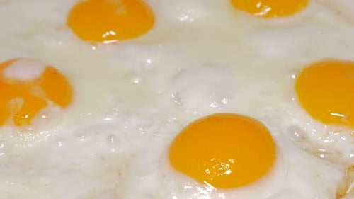 Eggs in pan frying on hot oil 4K 2160p UHD video - Organic eggs in ceramic frying pan and hot oil