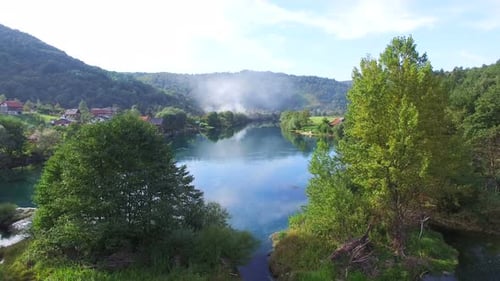 Flying above trees and clear water of Una river in Bosnia