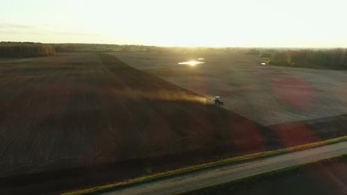 Tractor Plowing Field at Golden Hour, Aerial View