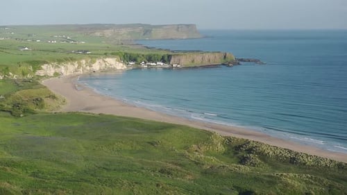 The beautiful waves of the Antrim Coast rolling to the beach of Ireland - wide shot