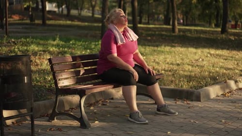 Femme en surpoids se reposant après avoir couru