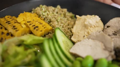 Woman Hands Put Bowl with Avocado and Turkey on Wooden Table