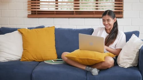 Excited Young Woman Works on Laptop at Home