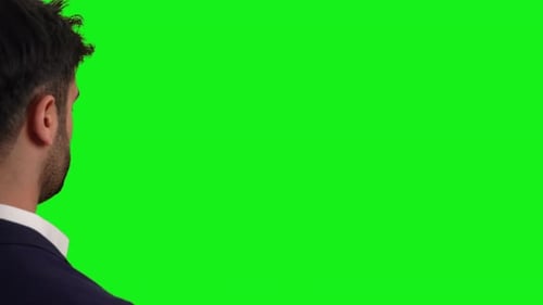 Geschäftsmann berührt digitalen Bildschirm. Grüner Hintergrund.