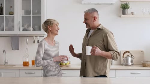 Couple Conversing and Drinking Coffee in Kitchen