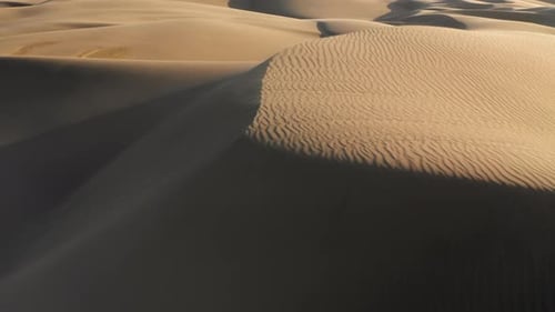 Aerial Drone View Flying on Top of Beautiful Wavy Sand Dunes Peaks at Sunset