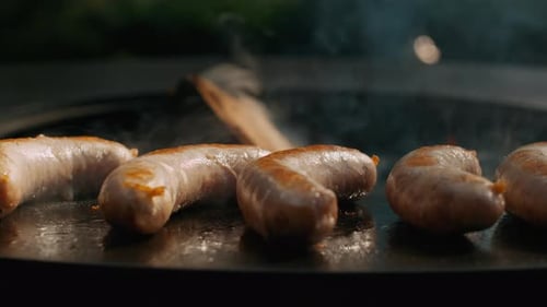 Juicy Sausages Preparing on Round Grill Outside