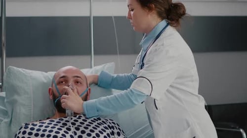 Close Up of Sick Man Patient Resting in Bed While Doctor Putting Oxygen Mask