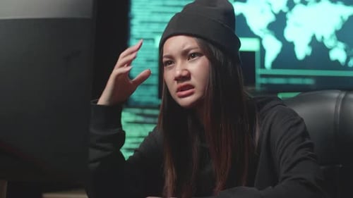 Junge asiatische Hackerin nutzt Computer-Hacking und verärgert, Code auf mehreren Computerbildschirmen
