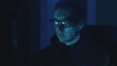 Young Man with Glasses Looking at Computer Screen