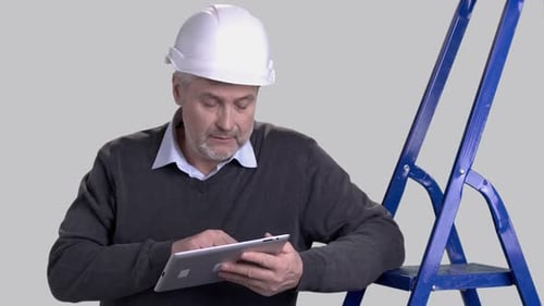Mature Architect Using Computer Tablet.