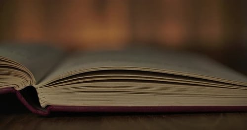 Antique Book Pages Turning on Wood Surface