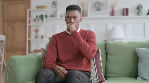 Young Adult Coughing on Green Couch
