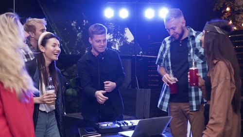 Young Adults Dancing with DJ at Night