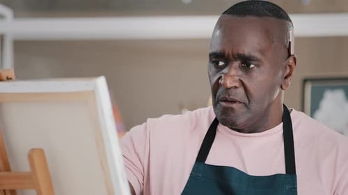 Close Up Concentrated Serious Pensive Talented Elderly African Male Artist Old Man Painter Drawing