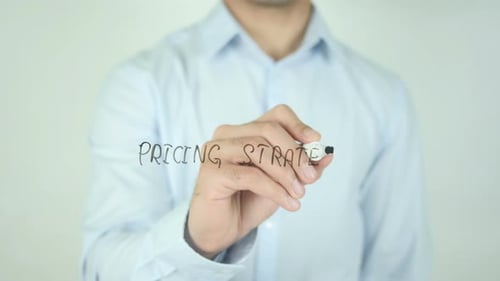 Man Writes Pricing Strategy on Clear Screen