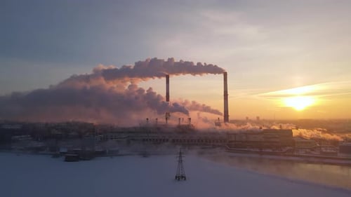 Smoke from industry plant chimney over sunrise sky background.