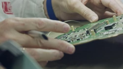Close up of manual soldering of a large circuit board