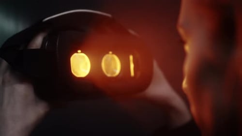 Person Holding VR Headset with Glowing Screens