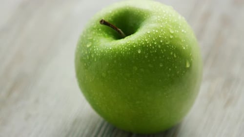 Grüner reifer Apfel mit Wassertropfen