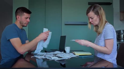 Man and Woman Looking at Payment Bills in the Kitchen