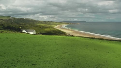 Beach Lodge Aerial Shot: Green Meadow Near Sea Bay and Lonely White Rocks, Northern Ireland