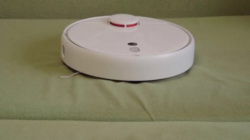 Finger presses button on robotic vacuum cleaner