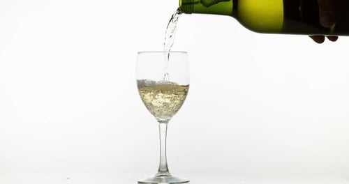 White Wine Pouring Into Glass on White