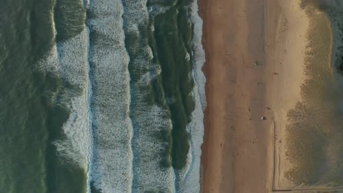 Beach with Sand Dunes and Blue Ocean Waves Crashing Against Shore Line, Aerial Birds Eye Top Shot